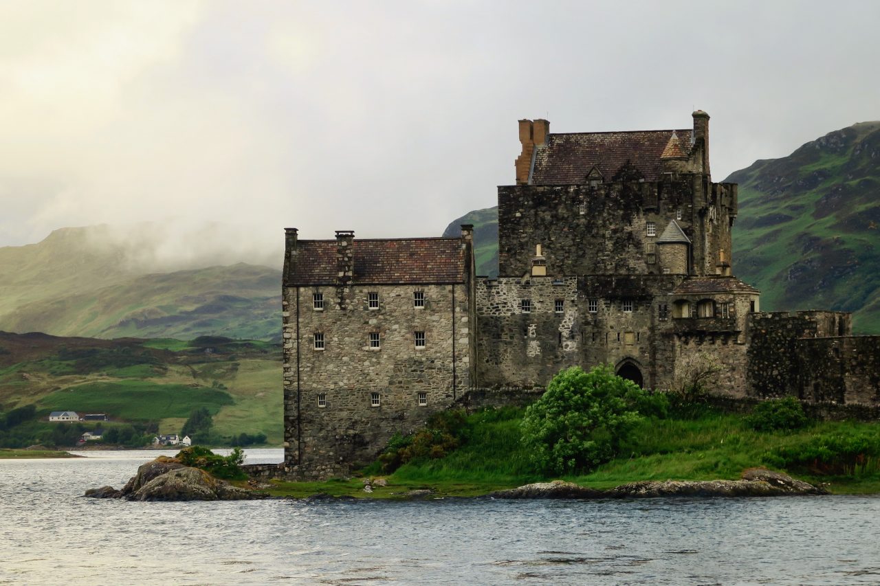 Historic Eilean Donan Castle on grassy shores by the water